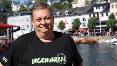 Smilende mann i t-skjorte med teksten "ingeniørene" 