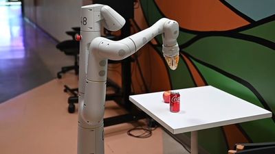 Robot som skal til å plukke opp en brusboks.