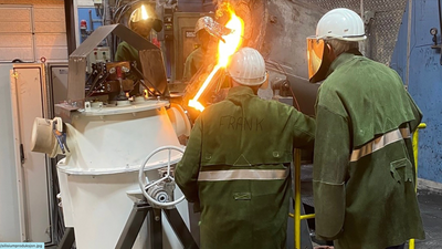 Tre mennesker i verneutstyr står foran en maskin og flammer.