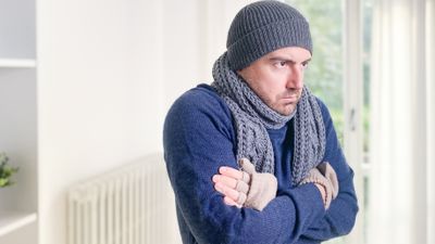 mann fryser foran radiator.