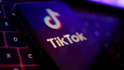 Logoen til Tiktok-appen på en mobiltelefon som ligger på et tastatur.