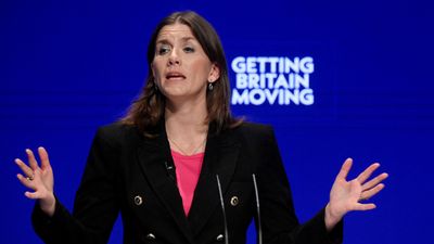 En kvinne på en talerstol. I bakgrunnen teksten Getting Britain moving.
