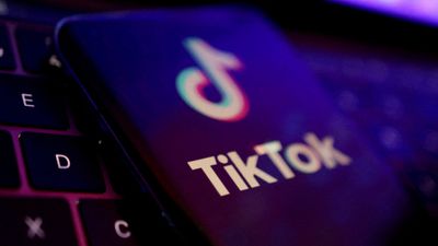 Logoen til Tiktok-appen på en mobiltelefon som ligger på et tastatur.