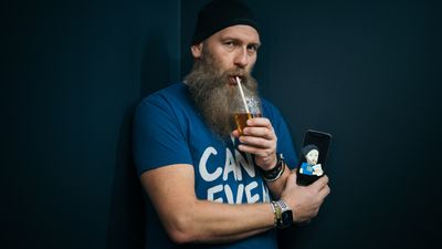 Yngvar Ugland drikker av et glass med sugerør. Det samme gjør hans metavers-avatar på mobilen. 