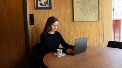 Kvinne som bruker en laptop på café