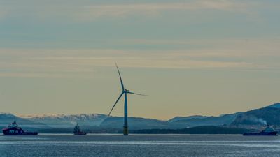 Et idyllisk bilde av en vindturbin på havet. 