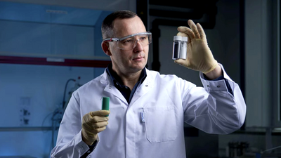 Hovedforfatter bak ny studie, Oleksandr Dolotko, står med et glass fylt med litiumkarbonat gjenvunnet fra en batterikatode.