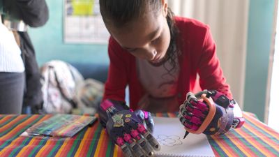 Mia Rodriguez (11) viser fram hvordan hun kan bruke de nye 3D-printede hendene til å tegne en blomst på skolen i Salinas.