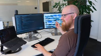 Jottacloudutvikler Jan Berge Sommerdahl viser stolt frem deres AI-bildesøk han sitter i en stol og peker på en skjerm