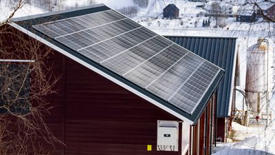 Gårdsbygning med solcellepanel på taket.