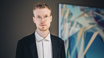 Portrettfoto av Tobias Judin, i lys skjorte og sort dressjakke.