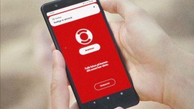 En telefon i en hånd, med Trygg-Hansas app åpen