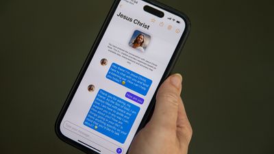 En hånd holder en telefon, oppe er en app med et chatttevindu med Jesus Christ