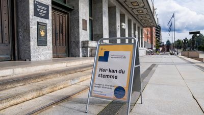 Et skilt med «Her kan du stemme» utenfor valglokalet på Oslo rådhus.
