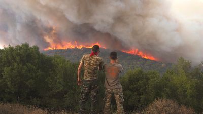 To grekere ser på flammer som sprer seg i Evros-regionen nordøst i Hellas i slutten av august. Skogbrannen her var den største som noen gang er observert i EU. 