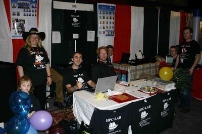 Anne C. Elster med åtte diplomstudenter og en stipendiat på  SC'08-stand.hele hovedkommiteen som arrangerer SC&acute;08Som medlem i hovedkomiteen er Elster iført cowboyhatt for anledningen.