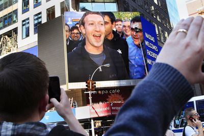 Mark Zuckerberg (på storskjerm i New York - direkte fra Facebooks hovedkvarter i California fredag ettermiddag norsk tid) jubler over den historiske børsnoteringen. Men få av investorene hadde grunn til å juble. Aksjen endte marginalt over emisjonskursen på sin første handelsdag - og skuffet garantert en rekke investorer som håpet på en kjapp gevinst.