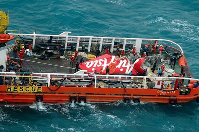 AirAsia-flyets haleparti ble lørdag hentet opp av havet. Her ligger det på dekk i redningsbåten Crest Onyx.  