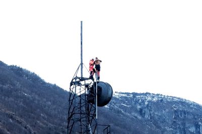 Mannskap fra Eltel strekker kabler fra Telenors mobile container og opp i mobilmasten som overlevde storbrannen i Lærdalsøyri.