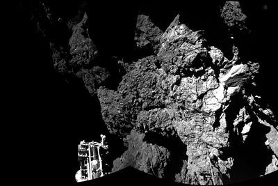 Her er Philae mens den står på bakken av kometen. Den ene foten til landeren kan skimtes nede til venstre.