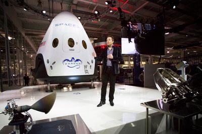 SpaceX-sjef Elon Musk, som også er sjef i Tesla, poserer foran den nye romkapselen som etter planen skal ta med seg mennesker ut i verdensrommet og tilbake igjen allerede i 2017. 