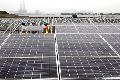 Arbeidere er i ferd med å sette opp et solcellepanel på et kraftverk i Japan. Solcellepaneler fra Kina har skapt problemer på det europeiske markedet, men nå vil EU rydde opp.