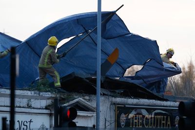 Redningsarbeidere dekker over vraket av politihelikopteret som kræsjet på taket til Clutha Vaults pub i Glascow.