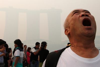 En turist gisper etter luft i Singapore, der smog – forurenset tåke – fra brenning av regnskog i nabolandet Indonesia har ført til forurensning på helsefarlig nivå.