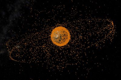 SKROT: Illustrasjonsbilde av romskrot i bane rundt jorden. Romskrotet er ikke skalert i forhold til jorden. 