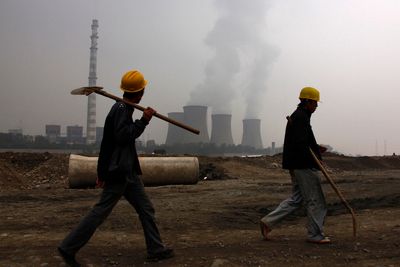 KULL: To arbeidere foran et kullkraftverk utenfor den kinesiske hovedstaden Beijing. Kullkraft er en av de viktigste kildene til utslipp av klimagassen CO2.
