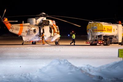 To norske Sea King redningshelikoptre på flyplassen i Kiruna torsdag kveld. Maskinene deltok i letingen etter et savnet norsk Hercules-fly som ble borte på tur mellom Evenes og Kiruna torsdag ettermiddag. 