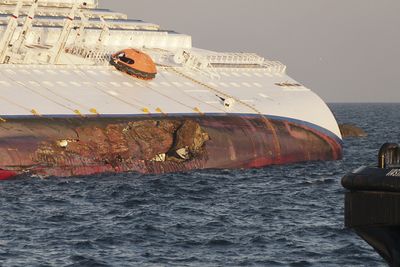 BUNNSKRAPT: En svær stein har boret seg godt fast inn skroget på Costa Concordia under grunnstøtingen. Flengen går gjennom flere vanntette skott. Store mengder vann trengte dermed inn.