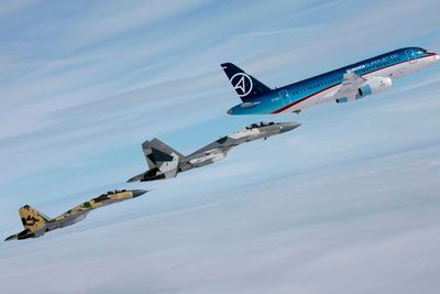 Passasjerflyet Sukhoi Superjet 100 flankeres av to kampfly fra samme produsent - Su-35 Super Flanker.