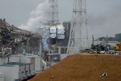 I GRUS: Reaktor 4 (i midten) og reaktor 3 (til venstre) ved Fukushima Daiichi kjernekraftverk i Japan. Bilde tatt 15. mars 2011.