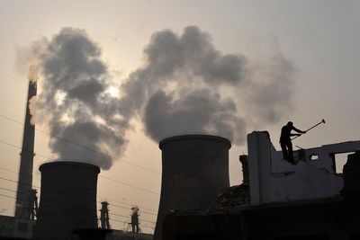 En arbeider jobber utenfor et kullkraftverk i Kina. Ingen land i verden har større utslipp av drivhusgasser enn Kina.