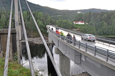 På dette bildet fra august i fjor var rivingen av hengebrua godt i gang. Tilskuerene står på den midlertidige gangbanen. Snart blir den erstattet av en påhengt gangbane på samme side.