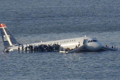 Passasjerene har kommet seg ut av flyet og står på vingene og venter på å bli reddet.