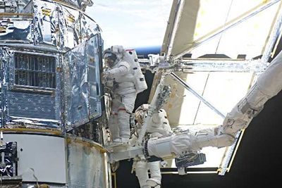 Astronauts John Grunsfeld (left) and Richard Linnehan work to replace the Hubble Space Telescope's power control unit during the last Hubble servicing mission in March 2002. Courtesy NASA.