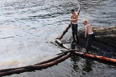 Mannskap fra Veolia Miljø suger opp olje i Krogshavn ved Langesund. Bilde tatt rett etter ulykken 31. juli i fjor.