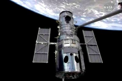 Robotarmen på romferja Atlantis grep onsdag om romteleskopet Hubble og trakk det med inn i romferjas lasterom for en omfattende overhaling.