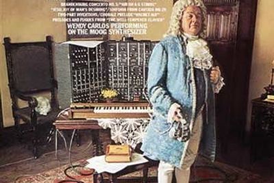 Platecover for Wendy Carlos' elektroniske musikkversjon av Johan Sebastian Bachs musikk, spilt på analog Moog Synthesizer i 1968. Klassisk skolerte musikere rev av seg parykken, mens ungdom fikk ørene opp for både klassisk og elektronisk musikk. Robert  Moog har igjen  begynt å produsere de populære, analoge MinMoog-ene. Mange unge musikere er lei det digitale lydbildet.