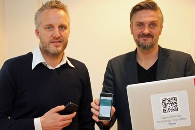 Lars-Thomas Stene og Daniel R. Döderlein i mCash med to av de vesentlige komponentene i selskapets betalingsløsning, en smartmobil og en QR-kode. De ansatte i selskapet skal forøvrig ikke ta skjegget før de har nådd 10 000 mCash-brukere.