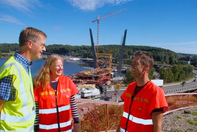 Sivilingeniør Øivind Pedersen (t.v.) hos Rambøll i Drammen, prosjektleder Gunn Brungot hos Statens vegvesen og hovedbyggeleder Ståle Singstad kan konstatere at Vestfolds nye landemerke, Farrisbrua (bak) i Larvik, begynner å ta form.