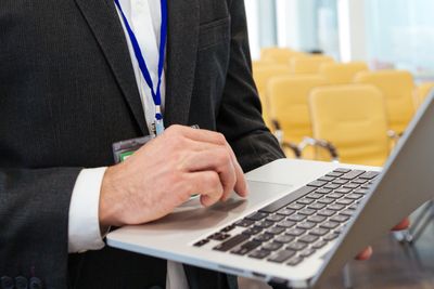 Concentrated businessman working with laptop in empty conference room