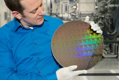 Nicolas Loubet ved IBM Research viser frem en wafer (silisiumskive) med brikker produsert med en 5 nanometer produksjonsprosess. Ifølge IBM skal dette bety 40 prosent ytelsesøkning med samme strømforbruk, eller 75 prosent redusert strømforbruk ved samme ytelse.