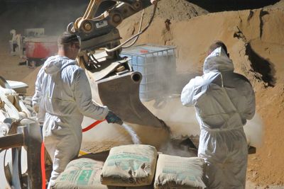 Forsvaret bygger base i Irak. Her jobber to personer med den manuelle tvangsblanderen, som produserer én kubikk betong av gangen.