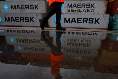 Illustrasjonsbilde: En man passerer tomme Mærsk-konteinere ved konteinerterminalen Peel Ports i Liverpool.