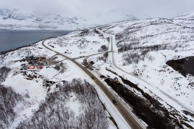 Den nye innfartsvegen til Skjervøy byr på bedre sikkerhet og fremkommelighet. Gammelvegen ses til høyre i bildet oppover bakken.    