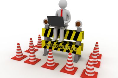 3d worker with laptop is sitting on an Under Construction sign. rendered illustration