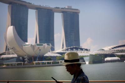 En turist sjekker smarttelefonen i Marina Bay Sands, Singapore. Byen er på topp i smartbyundersøkelser. Men på noen områder ligger Norge foran.